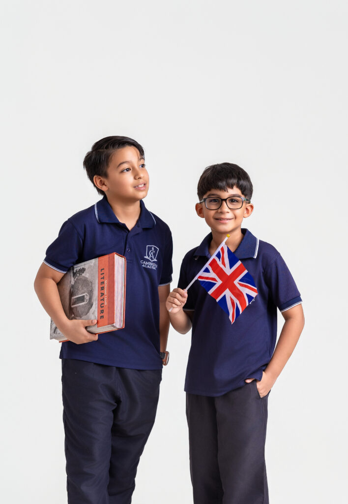 Estudiantes de primaria con libros y la bandera del Reino Unido